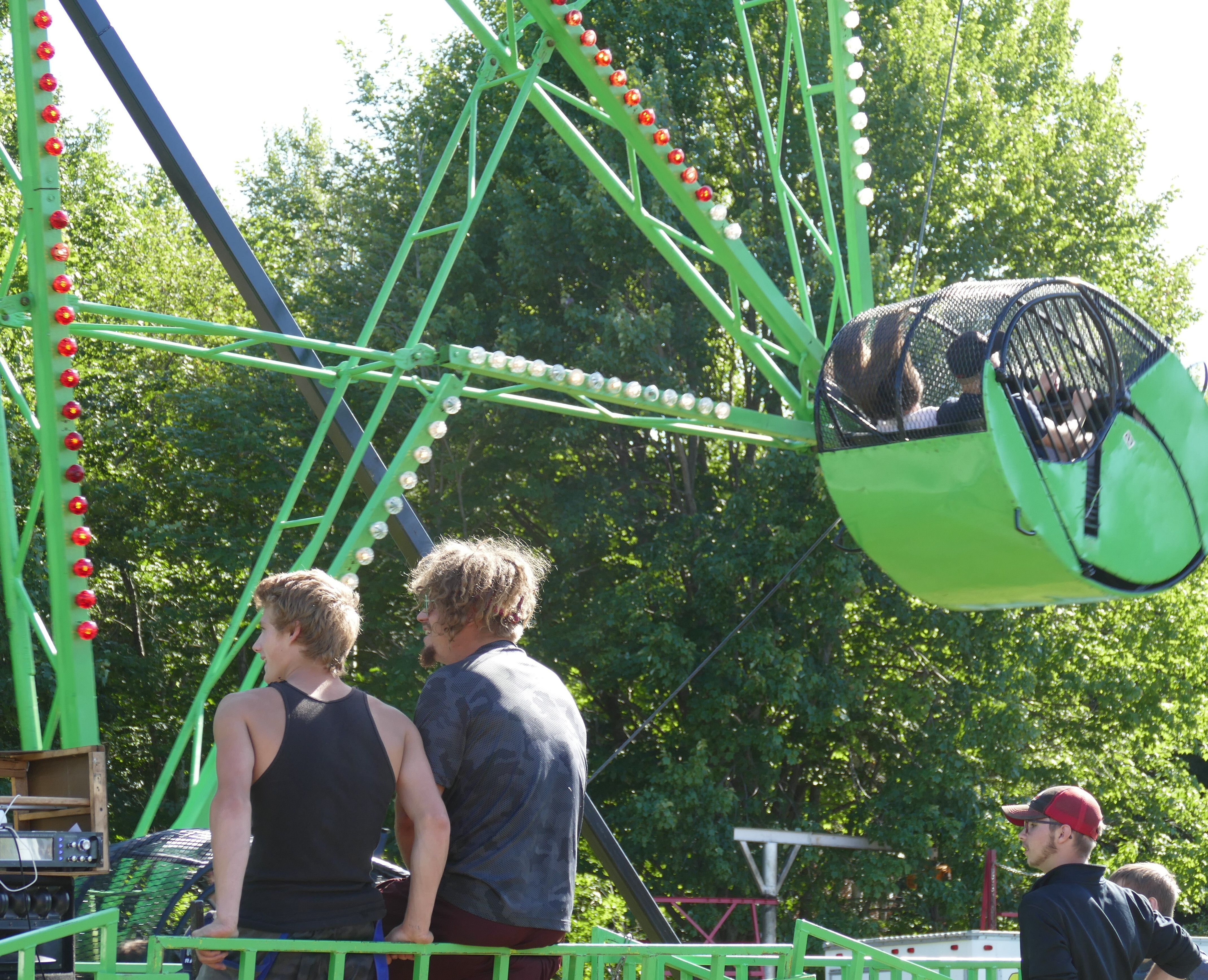 Boys watching the Ferris wheel ride at the county fair 
